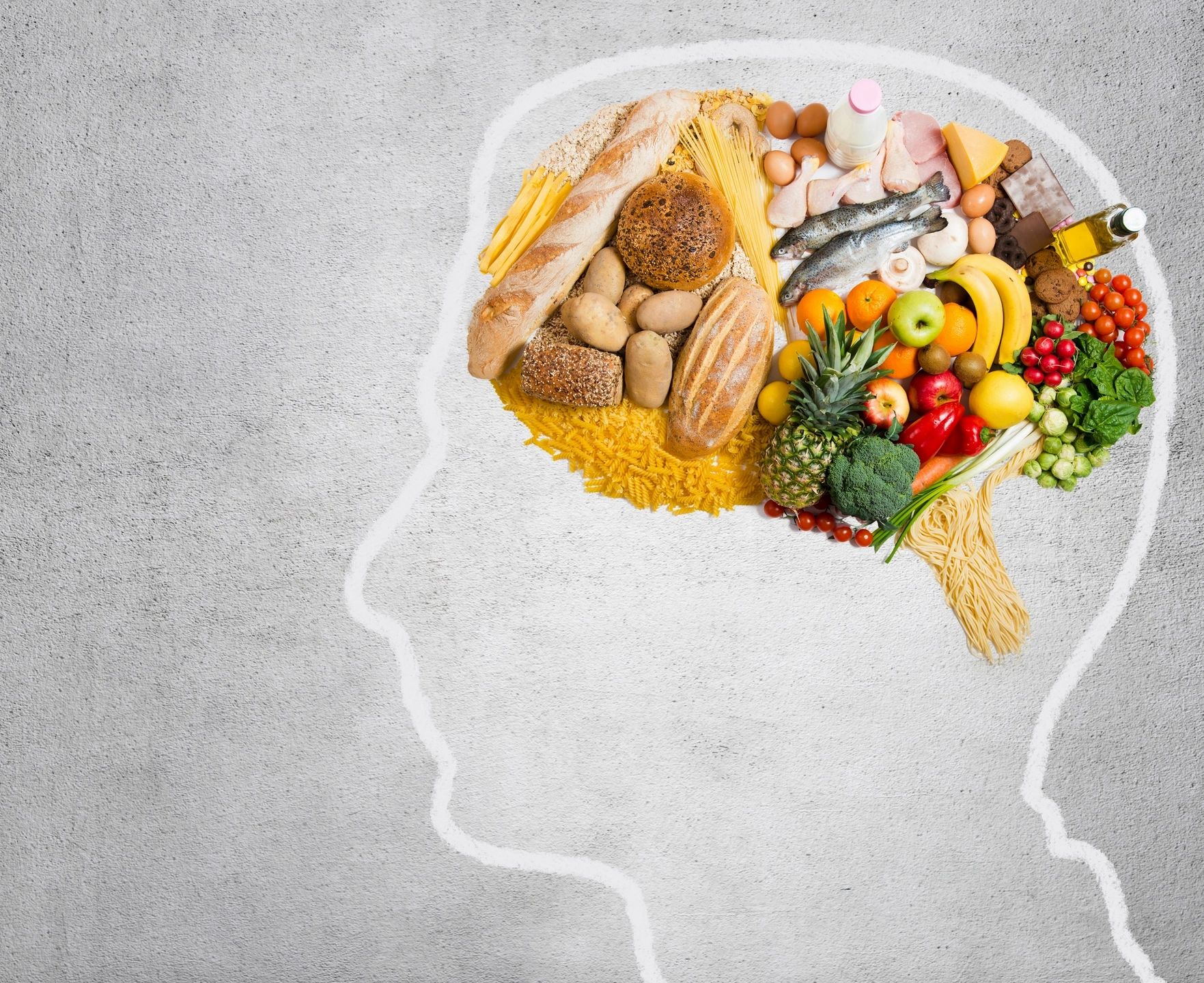Brain-shaped outline filled with various healthy foods like fruits, vegetables, bread, fish, and eggs.