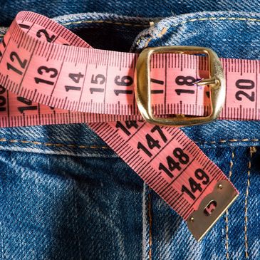 tape measure looped through a pair of jeans as a belt