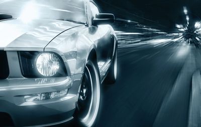 Close-up of a speeding car with motion blur effects at night.