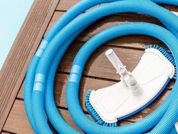 Pool hose and vacuum after a pool service.