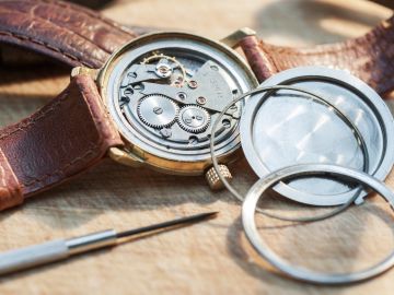Open watch showing internal gears and tools.