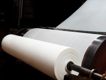 A large roll of white paper on an industrial machine.