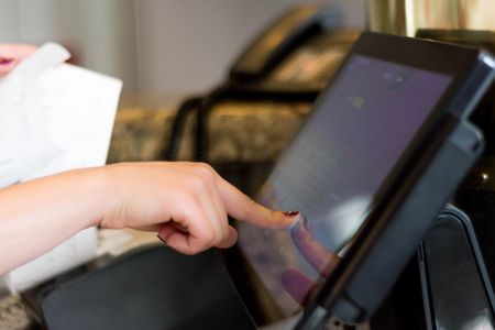 Person touching a Point of Sale screen ringing up a customer at a store