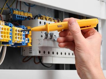 Electrician testing a fuse board