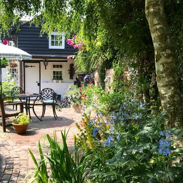 Cozy garden patio with seating and umbrella.