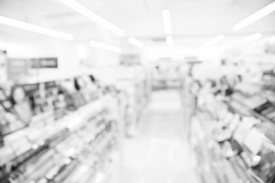 Blurred image of a store interior with shelves and bright lighting.
