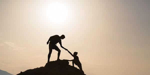 a man giving a hand to a woman for climbing 