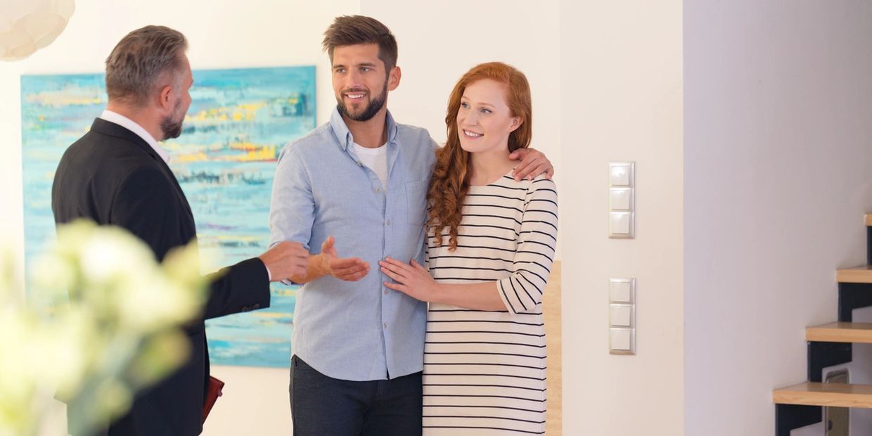 A couple are talking with their real estate agent about the home he is showing them.