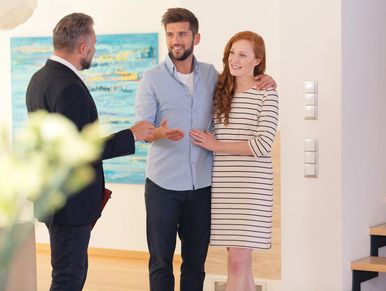 a couple talking to a real estate agent.