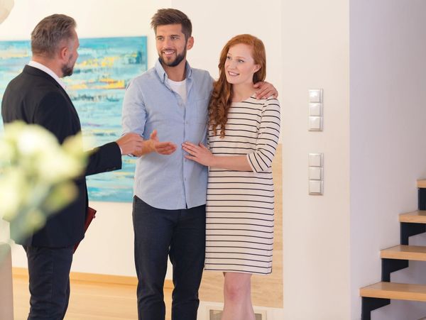 Realtor giving future tenants or first time buyers a tour of modern apartment