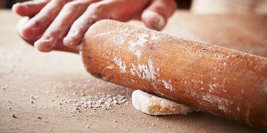 Rolling dough with a wooden pin.