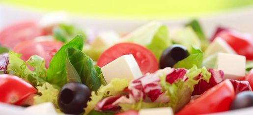 Fresh salad with tomatoes, olives, lettuce, and feta cheese.