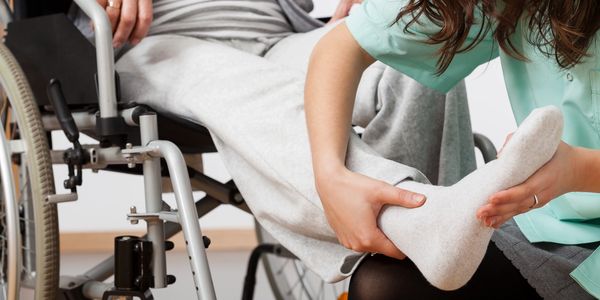 Nurse helping person to get in wheel chair