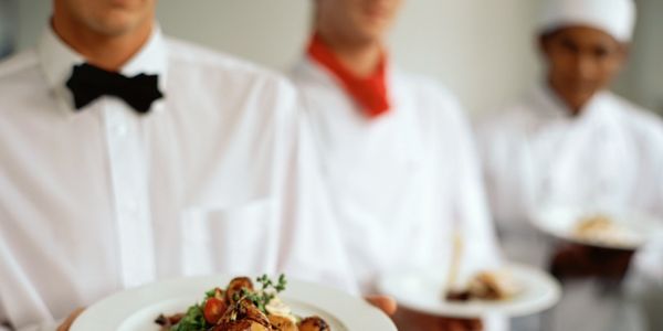 Waiters holding plates of food.