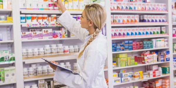Pharmacy worker checking medecine on shelves