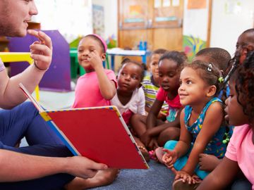 Teacher reading a book to children