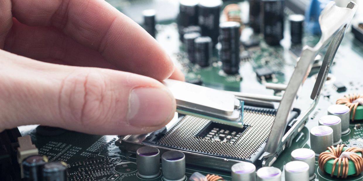 A close-up image of someone adding a piece of hardware to a computer's motherboard.