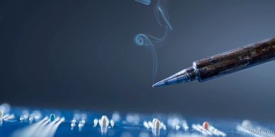 A soldering iron finishing soldering components to a circuit board. 