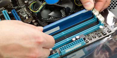 someone installing a stick of RAM into a motherboard on top of an electrostatic bag