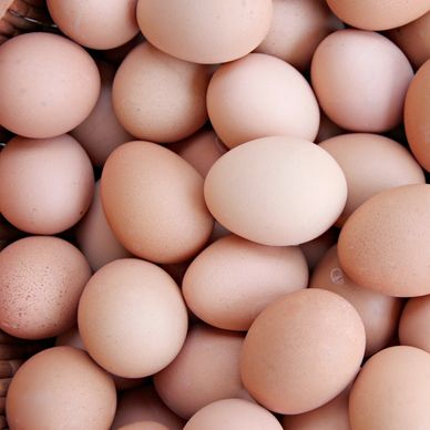 A pile of fresh brown eggs closely packed together.