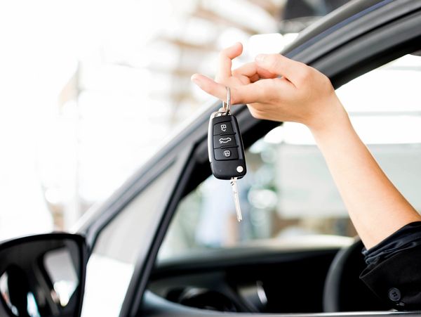 Driver in a car holding car keys. 