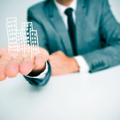 Businessman holding a digital drawing of buildings in his hand.