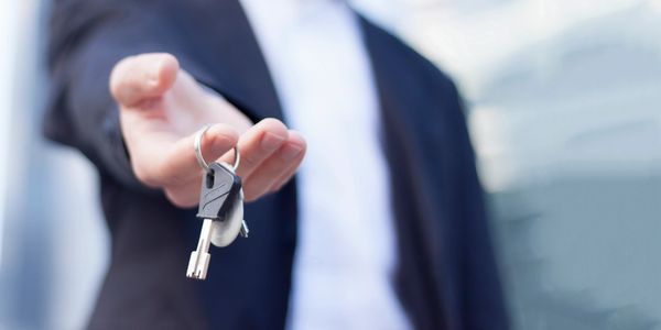 a man holding the keys to a house.