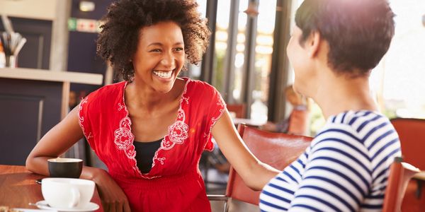 People smiling and talking over coffee