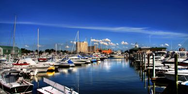 Boats docked at a marina under a clear blue sky.