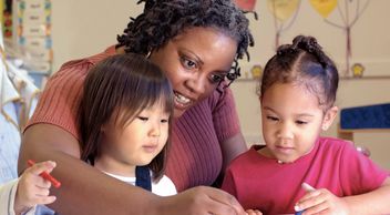 teacher working with young students