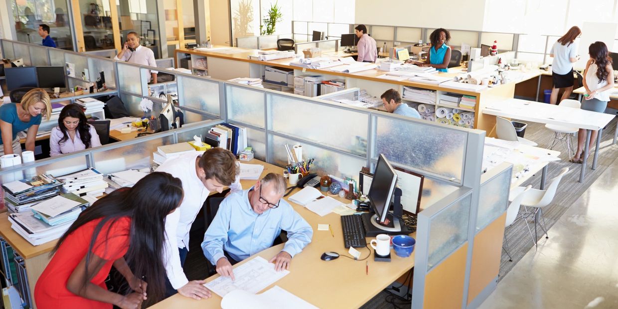 Busy open-plan office with diverse employees collaborating and working.