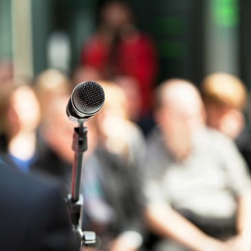 A microphone with an audience in the background.