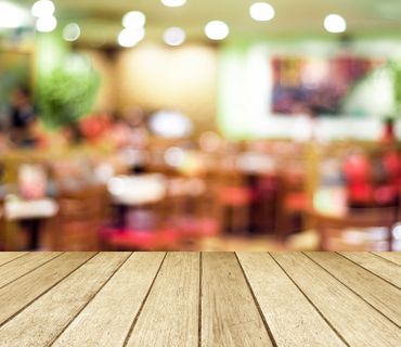 Empty wooden table with blurred restaurant background.
