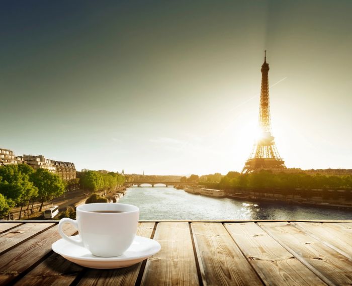 A cup of coffee overlooking the Eiffel Tower at sunrise in Paris.