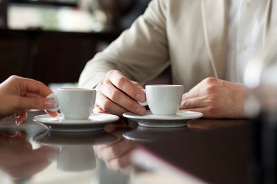 Hands of two people meeting over coffee to discuss their Nashville company's accounting needs.