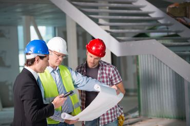 Three looking at construction plans