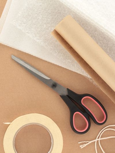 Scissors, thread and packing paper