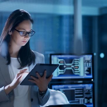 A woman with straight hair working on a smart tablet 