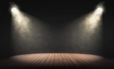 Empty stage with two spotlights in a dark room.