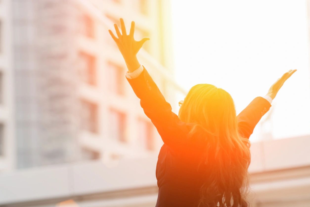 A woman raising arms in the air.