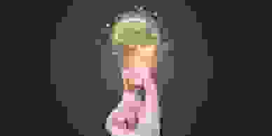 Hand holding an illuminated lightbulb containing a brain.