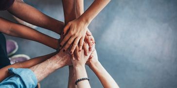 People stacking hands in unity.