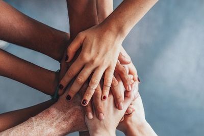 Diverse hands are stacked one on top of eachother.