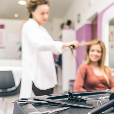 Hair stylist straightening hair.