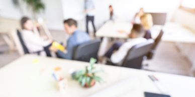 Blurred image of people in a casual office meeting.
