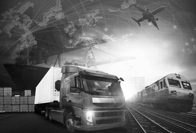 Multimodal transportation including truck, train, ship, and airplane in black and white.