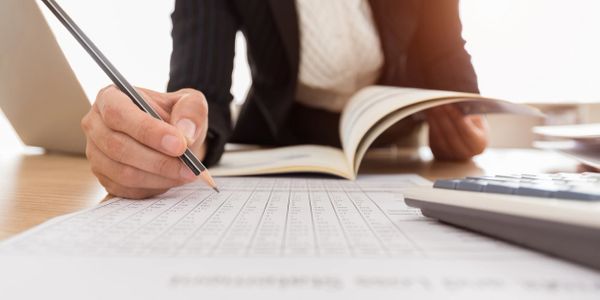 hand reviewing a chart with a pencil