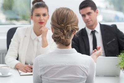 A young woman being interviewed by a man and a woman