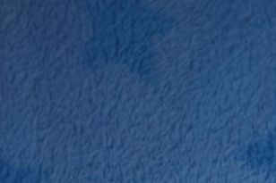 A baby boy asleep on a blue blanket.