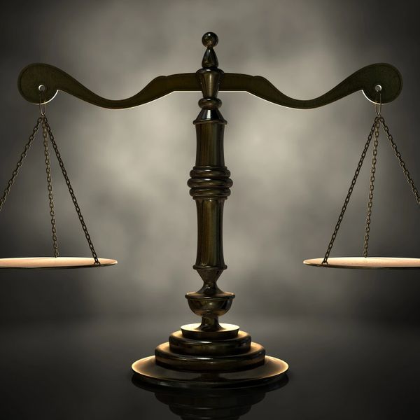 A bronze statue of the scales of justice.